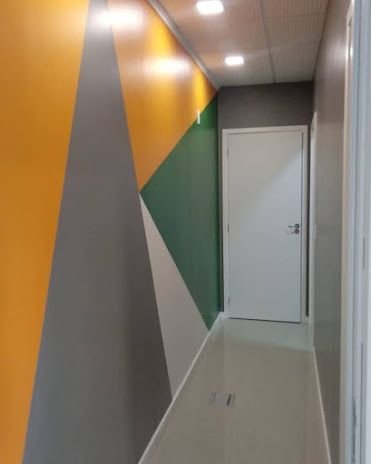 Corredor pintado pela Wave Colors com faixas geométricas em amarelo, cinza e verde